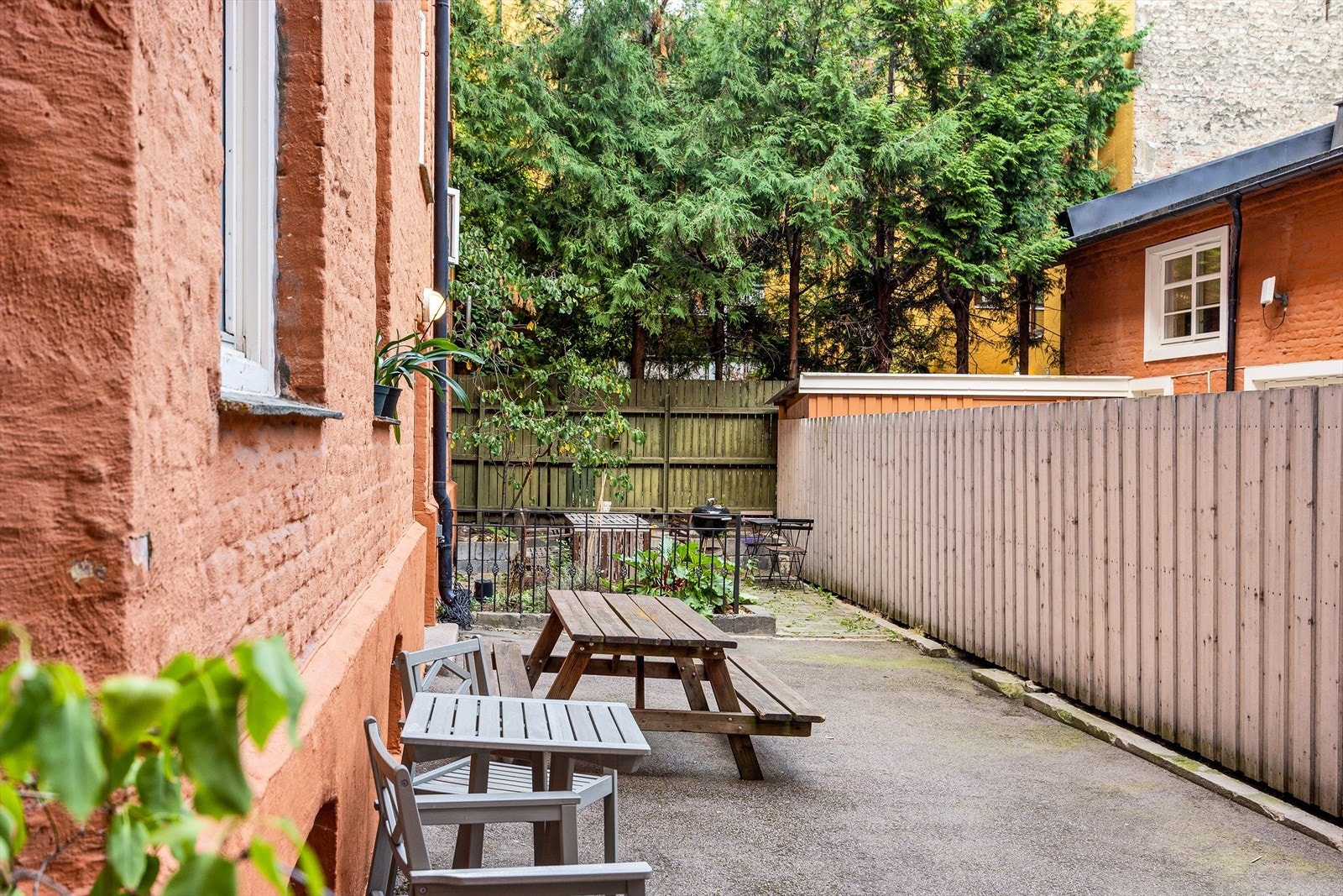 Bakgården er asfalter med flere sittegrupper Galleribilde