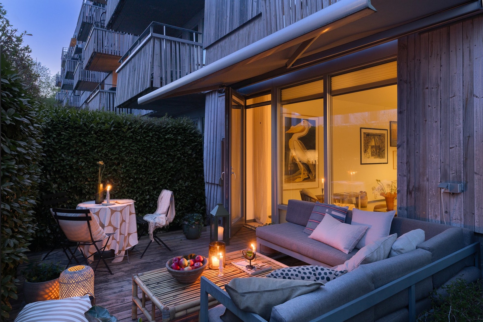Fra stuen er det utgang til en skjermet og solrik markterrasse på ca. 13 kvm. Hekk på bildet er AI redigert for å vise frodighet på sommer. Galleribilde
