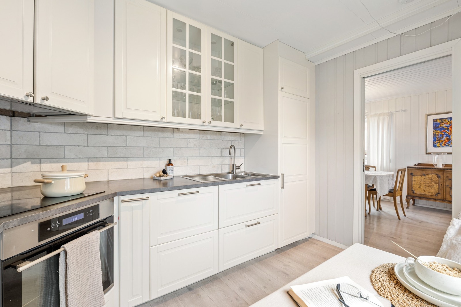 Innredningen består av profilerte fronter i fabrikkmalt utførelse og laminert benkeplate med nedfelt oppvaskkum, 1-greps blandebatteri og avstengningskran for oppvaskmaskin. Galleribilde