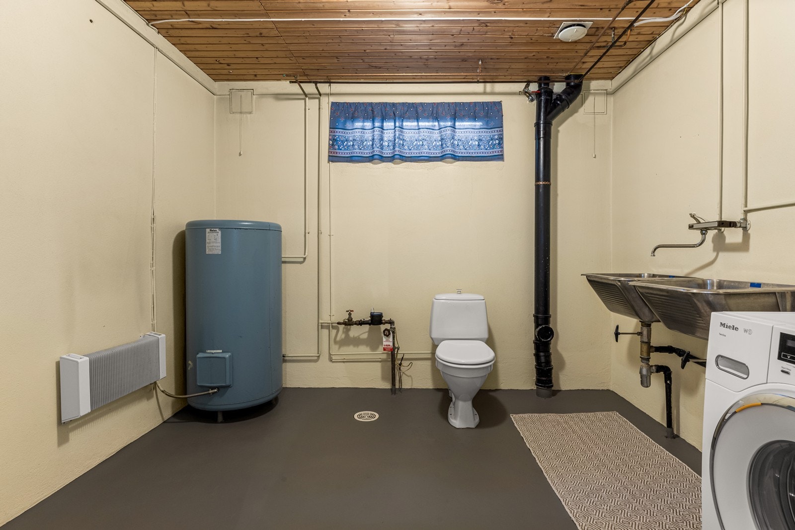 Vaskerommet i kjelleren har to utslagsvasker i rustfritt stål og opplegg til vaskemaskin. Galleribilde