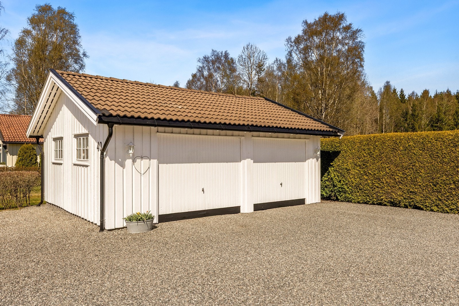 Garasjen er en frittliggende bygning på 40 m², med støpt dekke og yttervegger i trekledning. Galleribilde