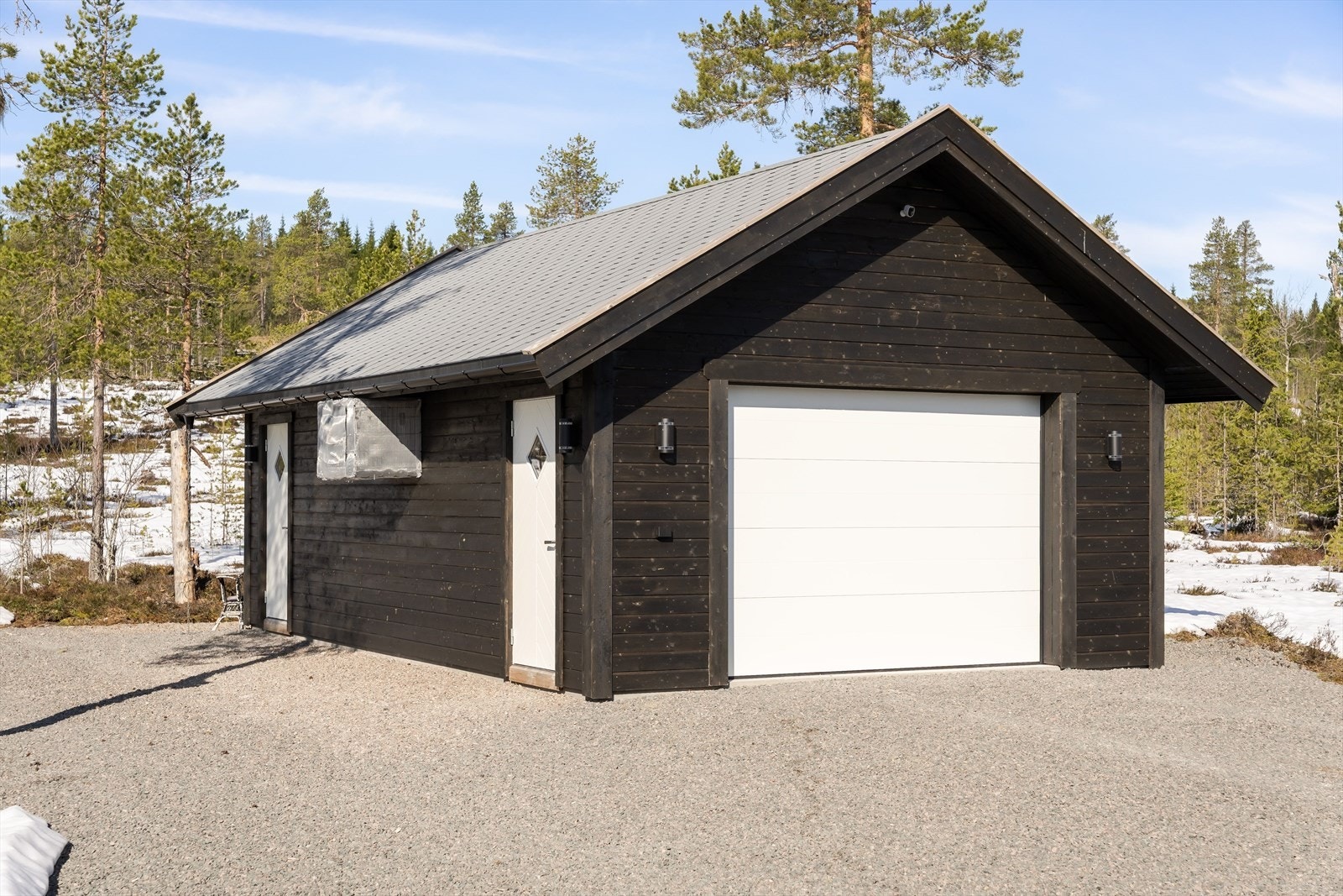 Frittstående garasje fra 2022 med leddport og innlagt strøm. Bygget inneholder også en praktisk bod. Galleribilde