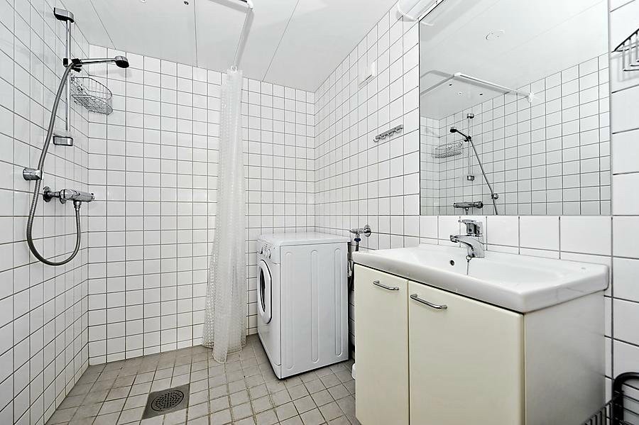 Flislagt bad med wc, servant, dusjhjørne og vaskemaskin Galleribilde