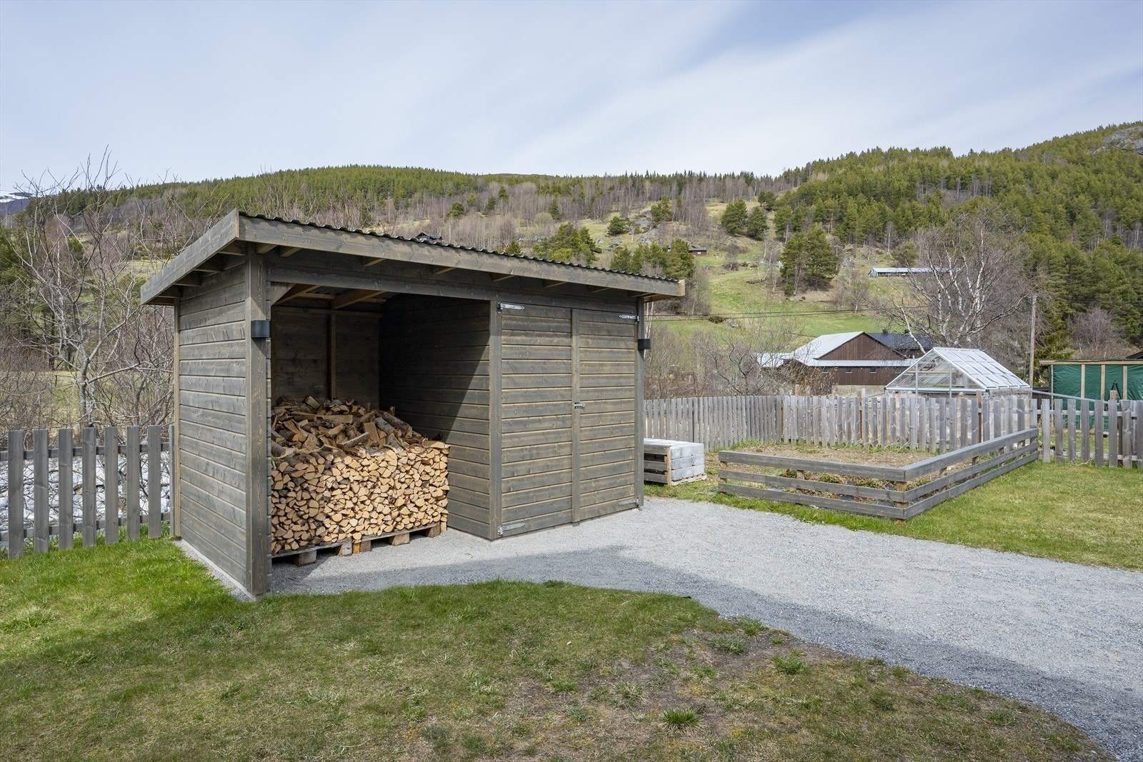 Bak på tomten er det satt opp et vedskjul/redskapsbod, og det er anlagt en liten kjøkkenhage. Galleribilde