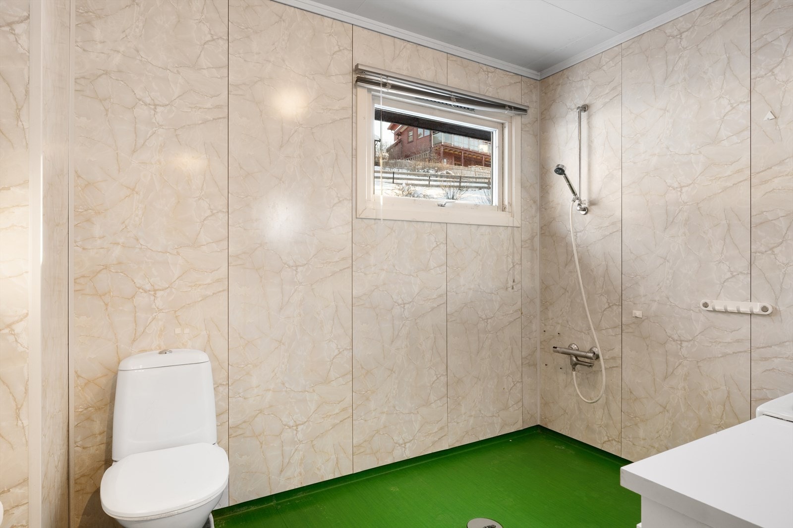 Badet for øvrig er utstyrt med dusjløsning og gulvmontert toalett. Galleribilde