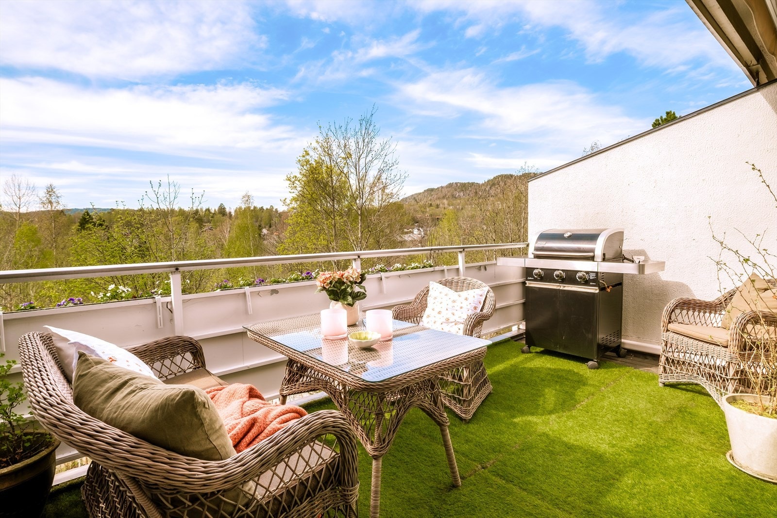 Balkongen fremstår som en herlig oase med god plass til både sittegruppe, spisebord og grill. Her kan du nyte lange sommerdager i usjenerte omgivelser. Det lune kunstgresset og den åpne utsikten mot naturen skaper en svært innbydende atmosfære Galleribilde