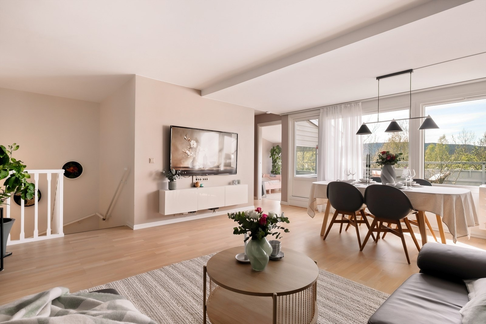 Stuen er selve hjertet i boligen, preget av en moderne og luftig atmosfære. En elegant kontrastvegg i dyp lilla gir rommet særpreg, mens store flater og lyst gulv binder sammen stue-, spise- og kjøkkensone på en harmonisk måte Galleribilde