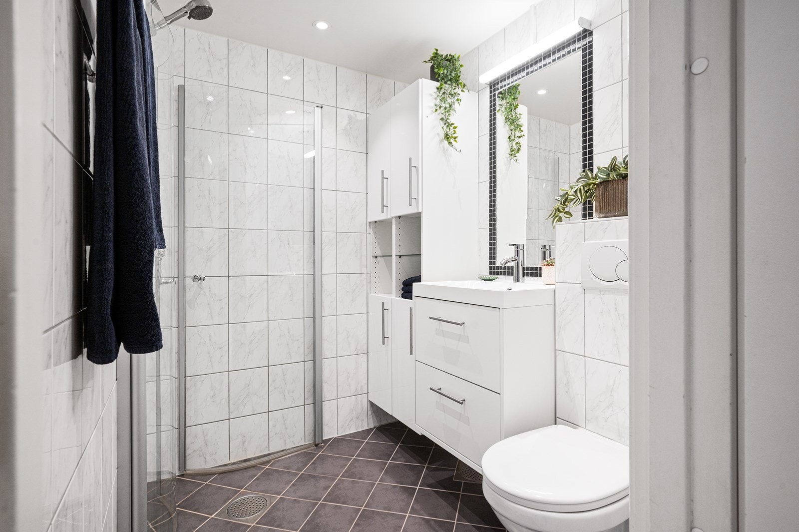 Pent og innbydende baderom med god lagringsplass. Pusset opp i 2008 i regi av borettslaget og oppgradert med nytt servantskap, servant og vannkran (2024) samt speillampe og nye LED downlights (2025). Galleribilde