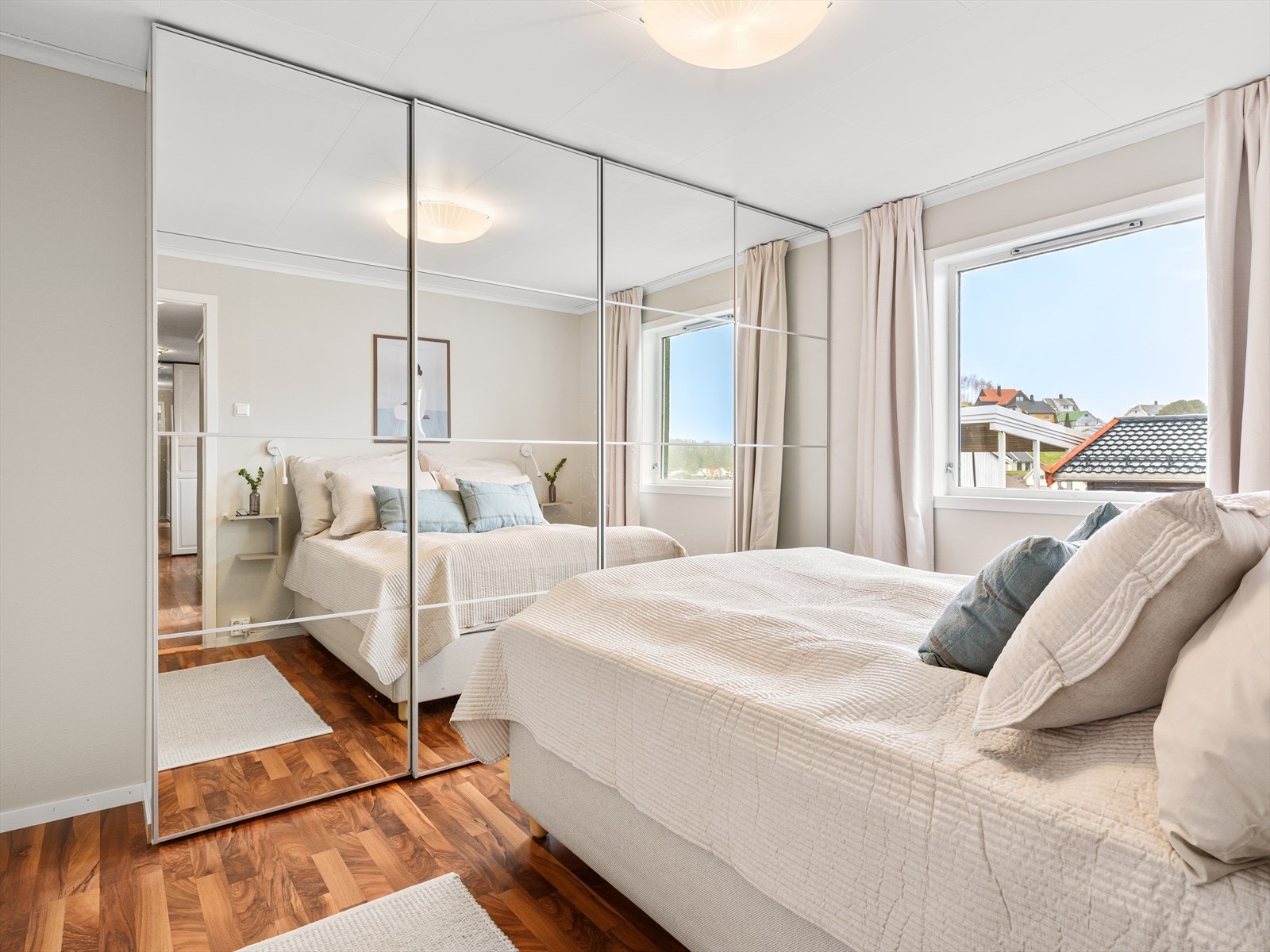 En stor skyvedørsgarderobe med speilfronter gir rikelig med oppbevaringsplass på soverommet. Galleribilde