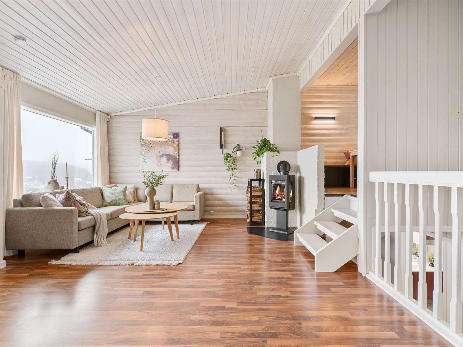 Den malte tretrappen med laminat i trinnene forbinder de to etasjene på en elegant måte. Galleribilde