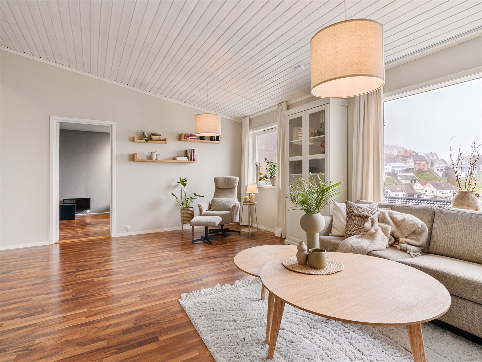 Stuen er et lyst og luftig rom med malt panel i taket Galleribilde