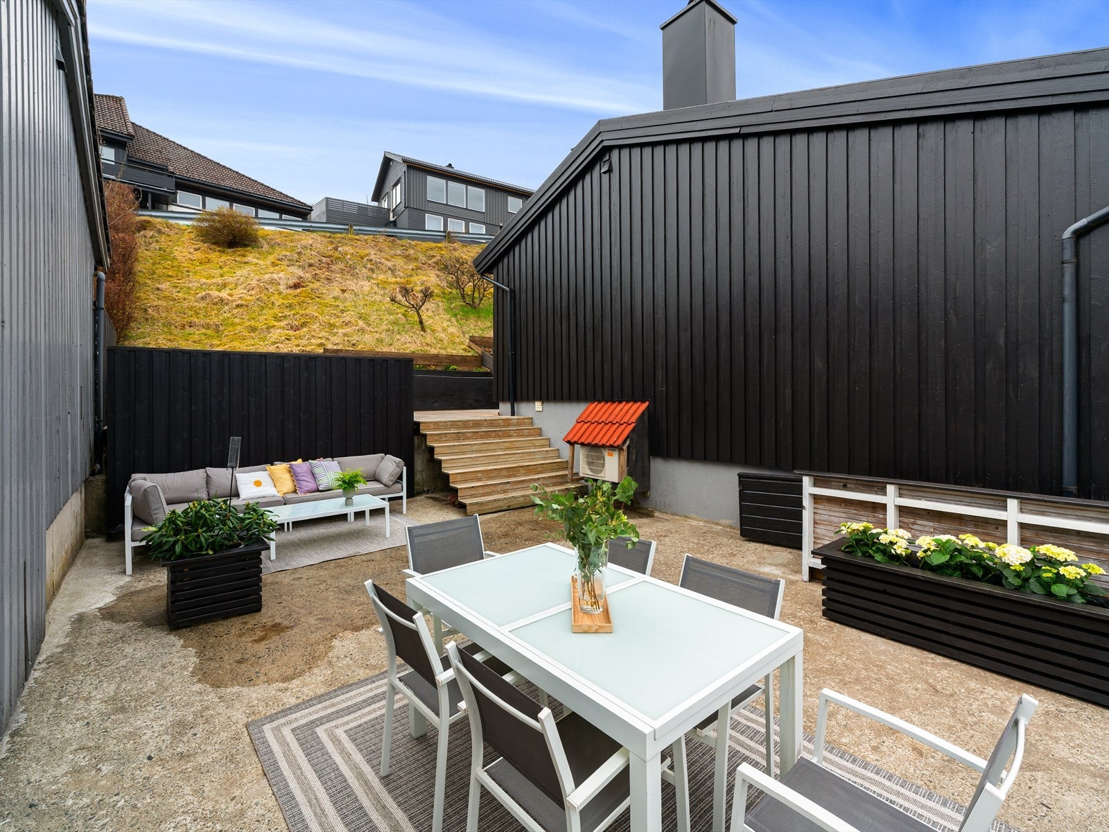 Uteområdet er etablert på boligens oppside, skjermet og med god plass for både avslapning og sosiale sammenkomster. Galleribilde