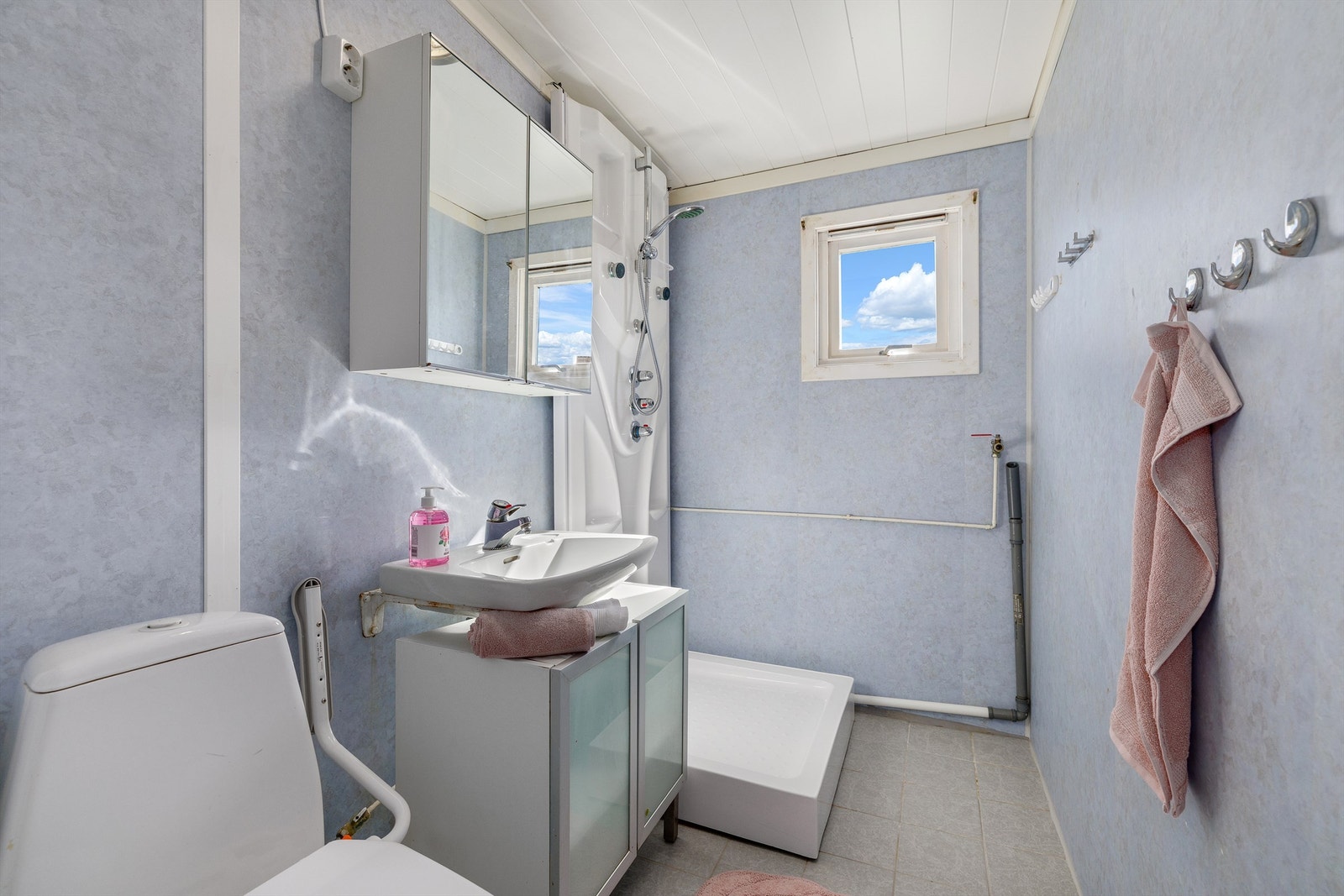 Badet har fliser på gulv og baderomsplater på vegg. Opplegg for vaskemaskin. Galleribilde