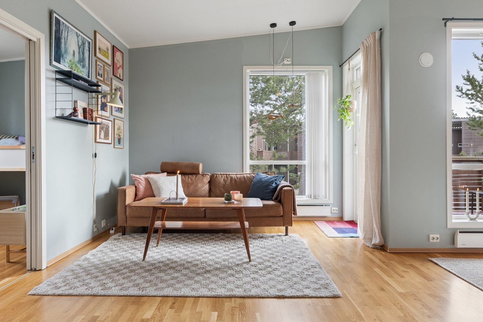 Sofagruppen har en fin og naturlig plassering ved vinduene, som gir godt med lys og en hyggelig atmosfære. Galleribilde