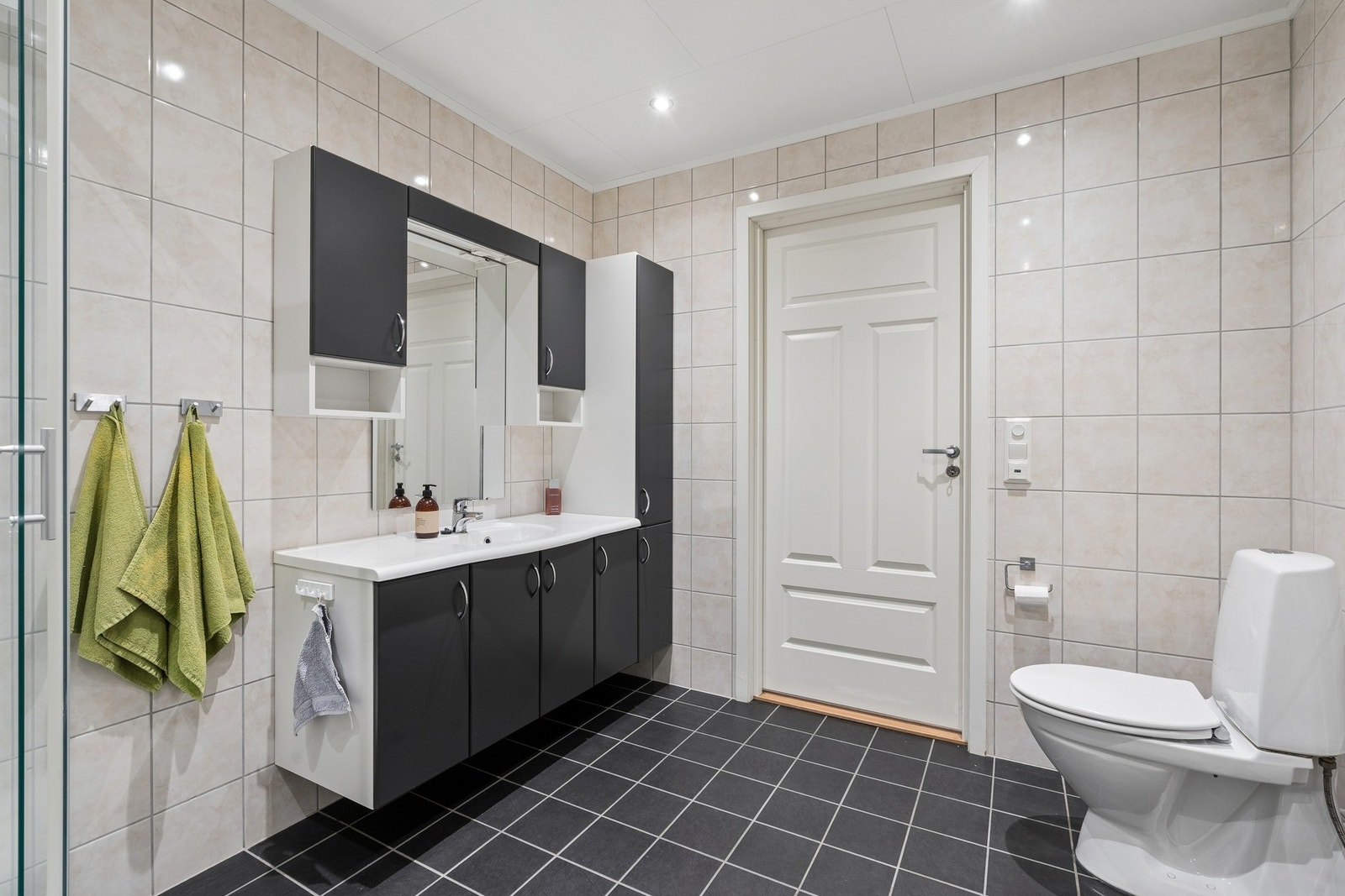 Innredningen består av dusjkabinett, gulvmontert toalett og servantmøbel med god oppbevaringsplass. Leiligheten har et eget vaskerom, som gjør at badet ikke trenger å være bare en arbeidssone. Galleribilde