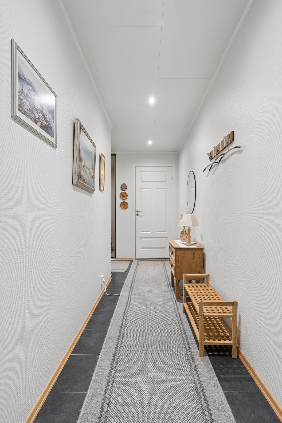 Gangen har flislagt gulv med varmekabler og downlights. Galleribilde