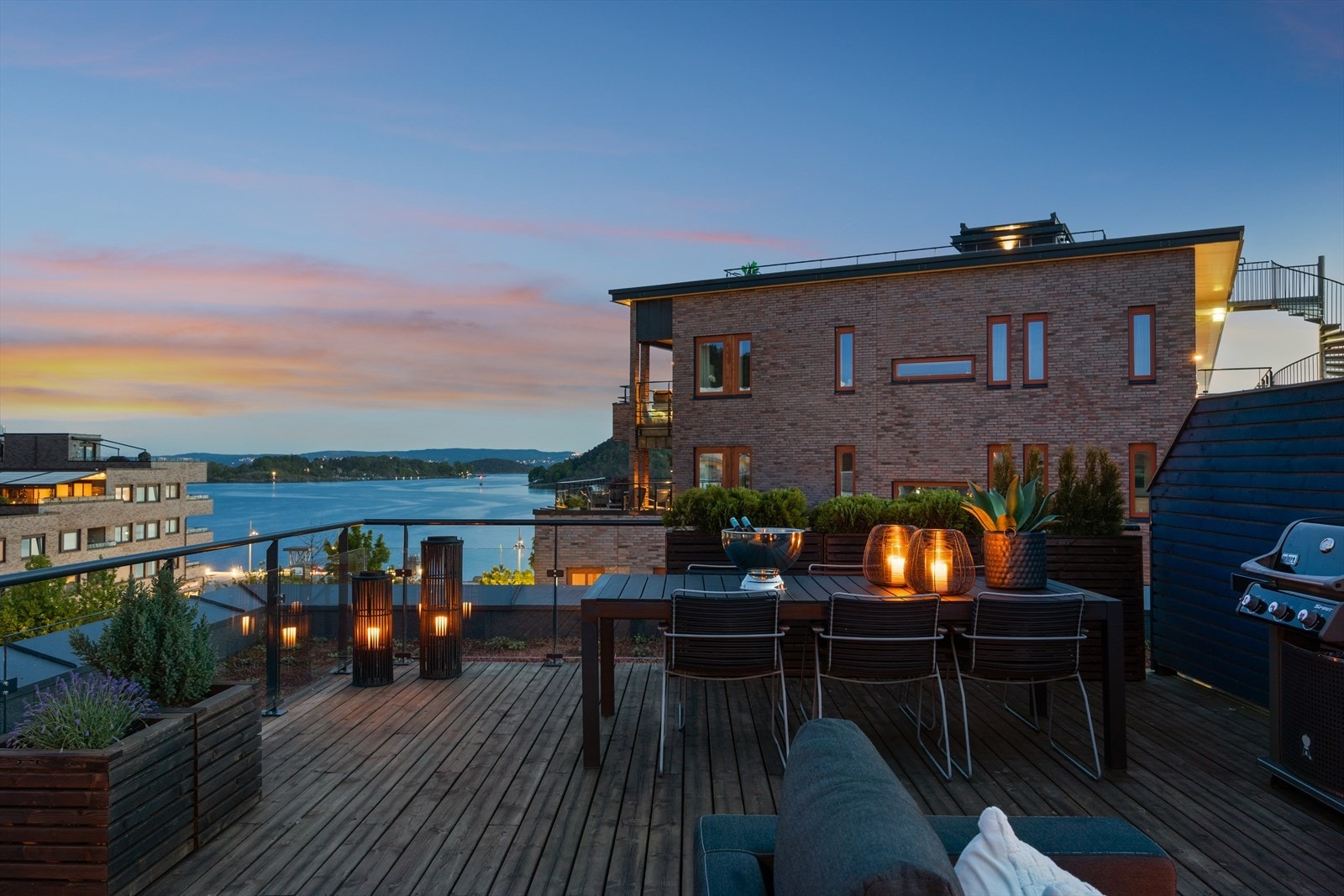 Kveldsstemning på den romslige terrassen - fjorden glitrer i bakgrunnen og rammen er satt for hyggelige sammenkomster i vakre omgivelser. Galleribilde