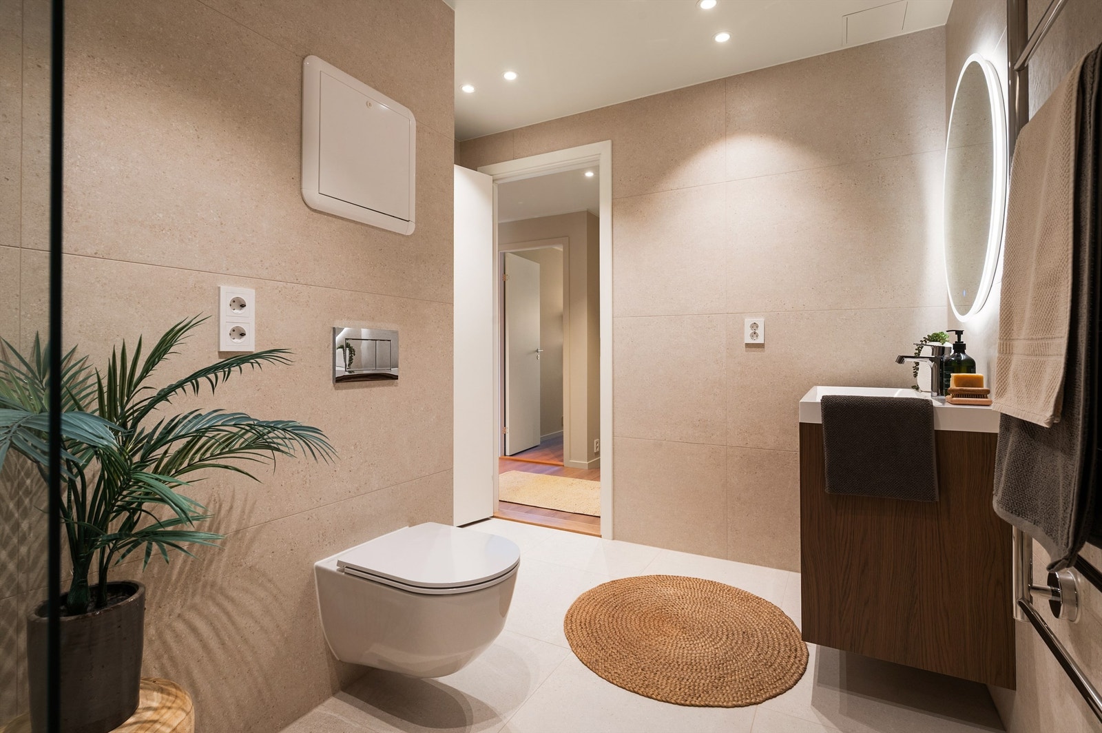 Badet er meget romslig. Detaljer som sort armatur og speil med integrert belysning understreker den gjennomførte stilen. Galleribilde