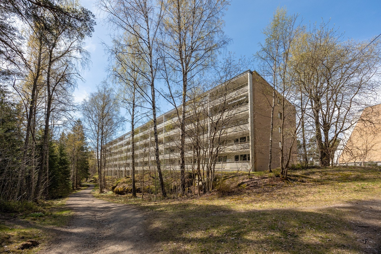 Blokken vender inn mot et stort fellesområde med grøntarealer, sittegrupper, gangveier og diverse beplantning. Galleribilde