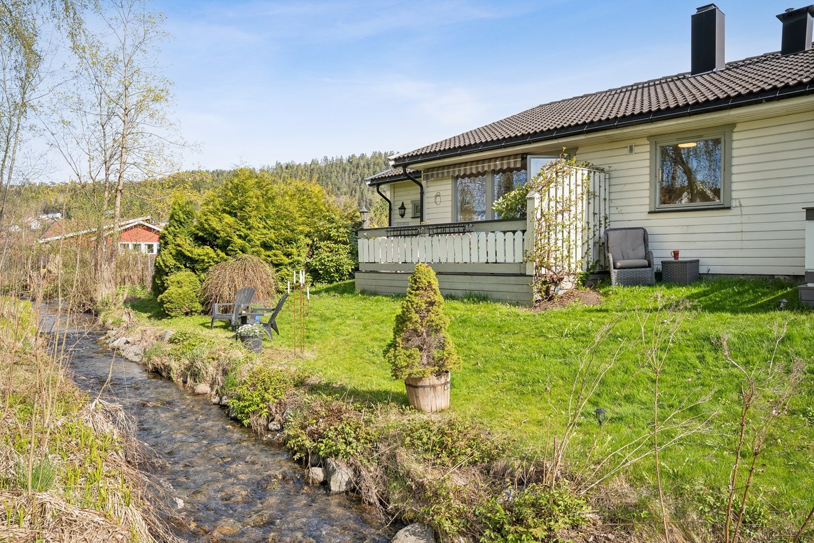 Tomten er pent opparbeidet med plen og beplantning. Galleribilde