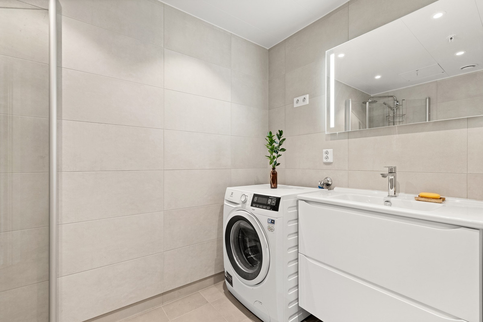 Badet er levert av Sigdal og har flislagte overflater, vegghengt toalett og opplegg for vaskemaskin. Galleribilde