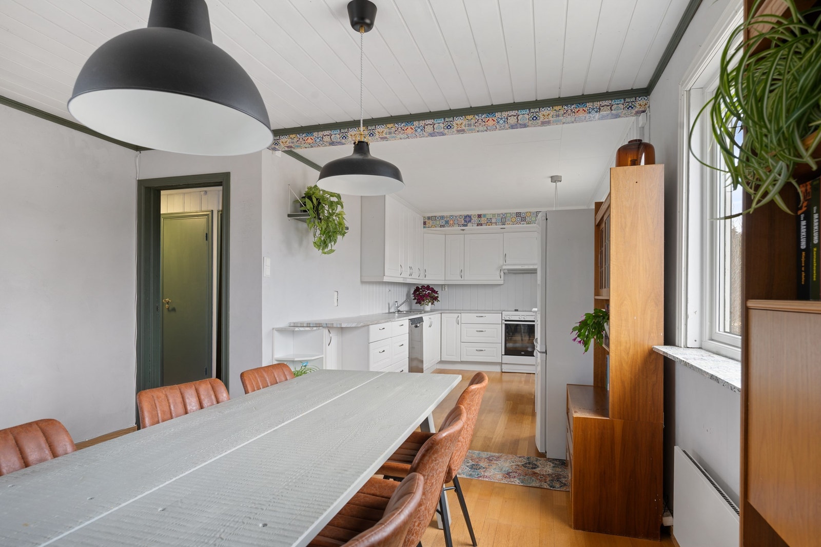 Fra spisestuen ser man rett inn i kjøkkendelen, praktisk for både hverdag og fest. Galleribilde