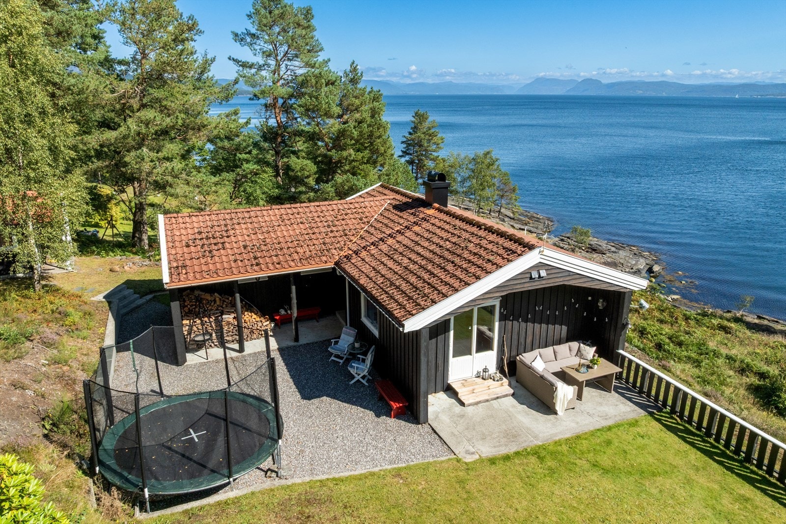 Kjekt terrasseområde utenfor stua og videre ut til plen og naturtomt. Galleribilde