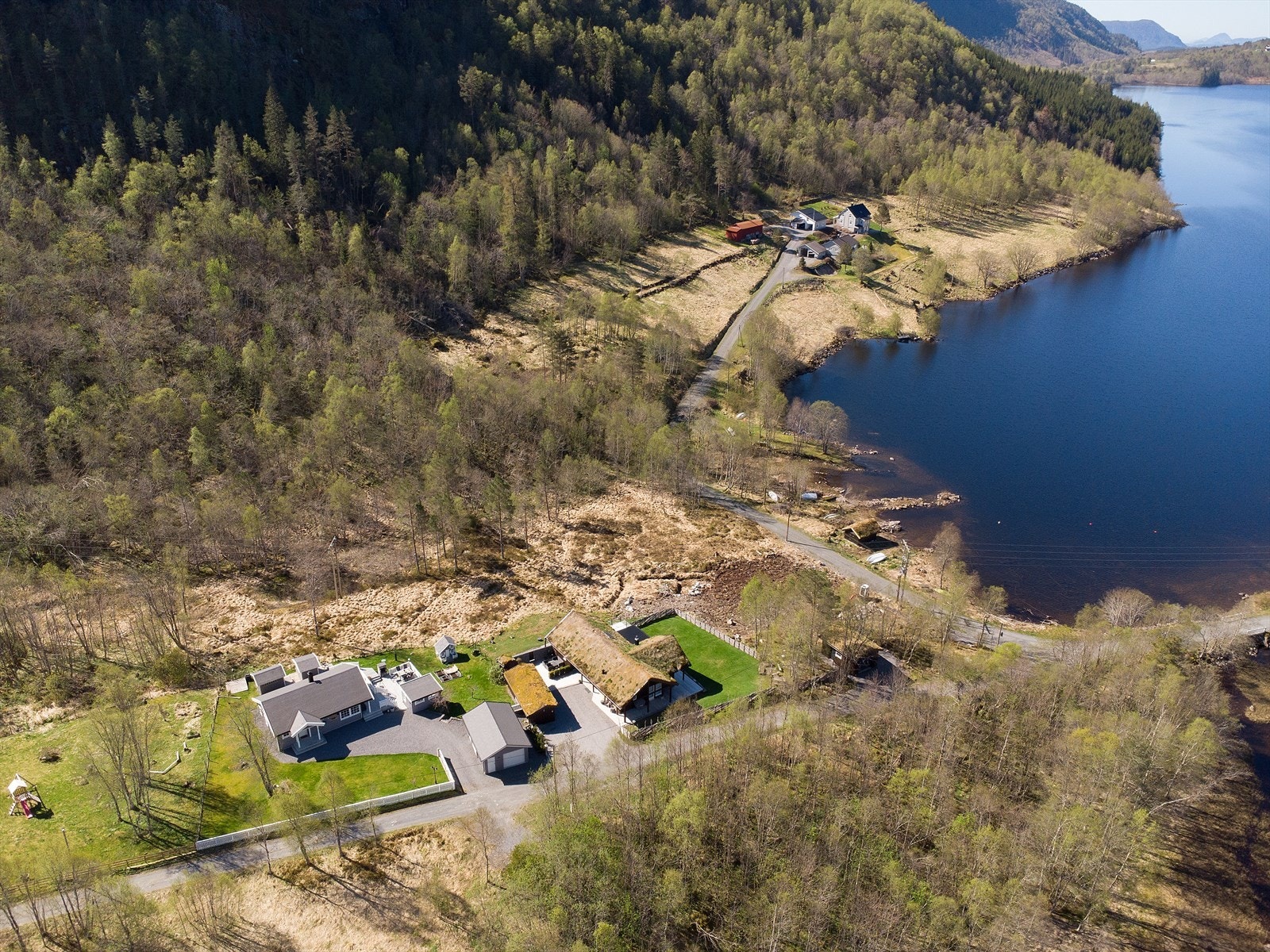 Eiendommen sett fra luften, med nærhet til både vann og skog. Galleribilde