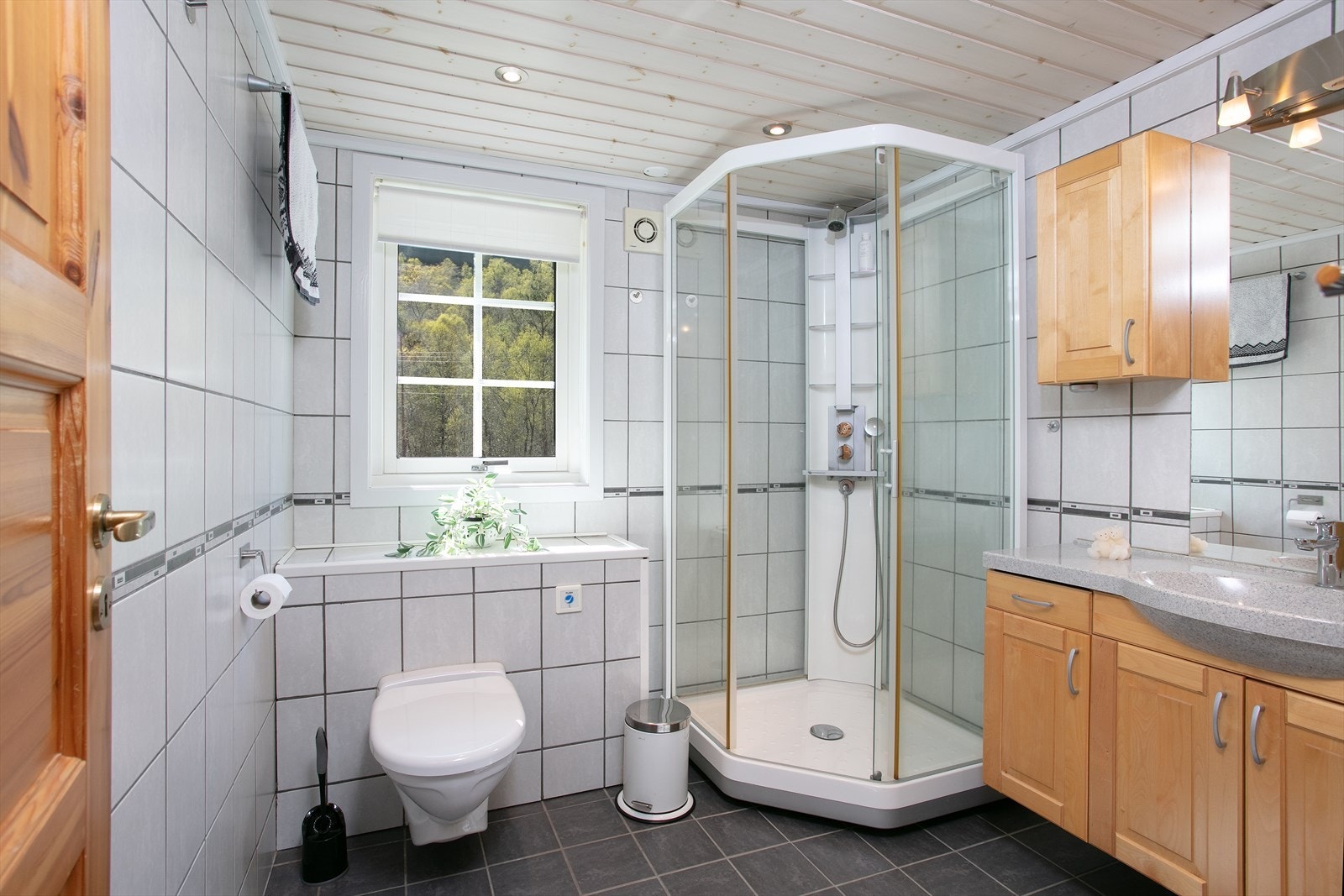Badet er helfliset med varmekabler i gulvet, dusjkabinett og vegghengt toalett. Galleribilde