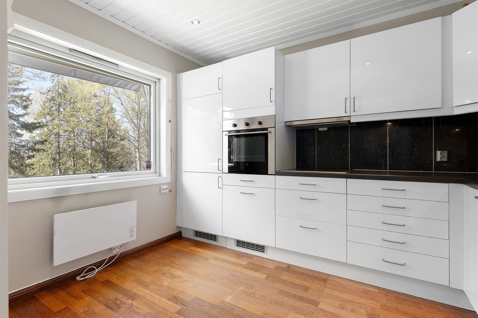 Pent kjøkken fra IKEA med integrerte hvitevarer, god benkeplass og oppbevaring i skap. Galleribilde
