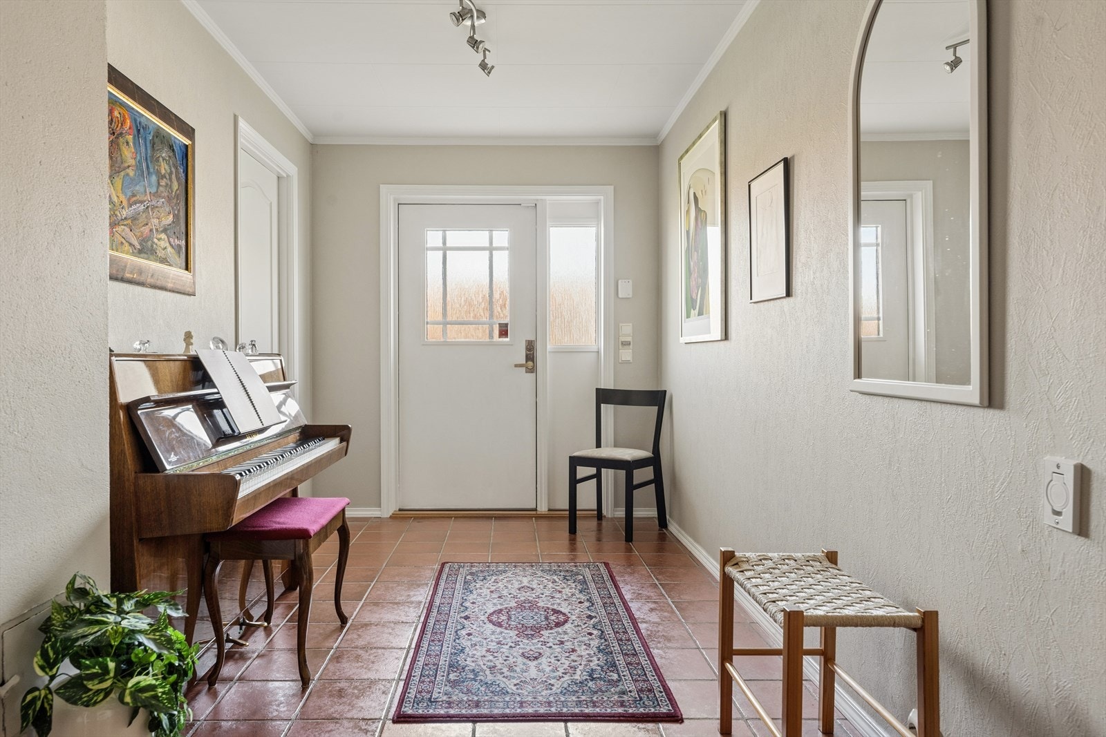 Man ønskes velkommen inn i en romslig gang som er praktisk innredet med flislagt gulv. Her har man god plass til å henge fra seg yttertøy og sko. Galleribilde
