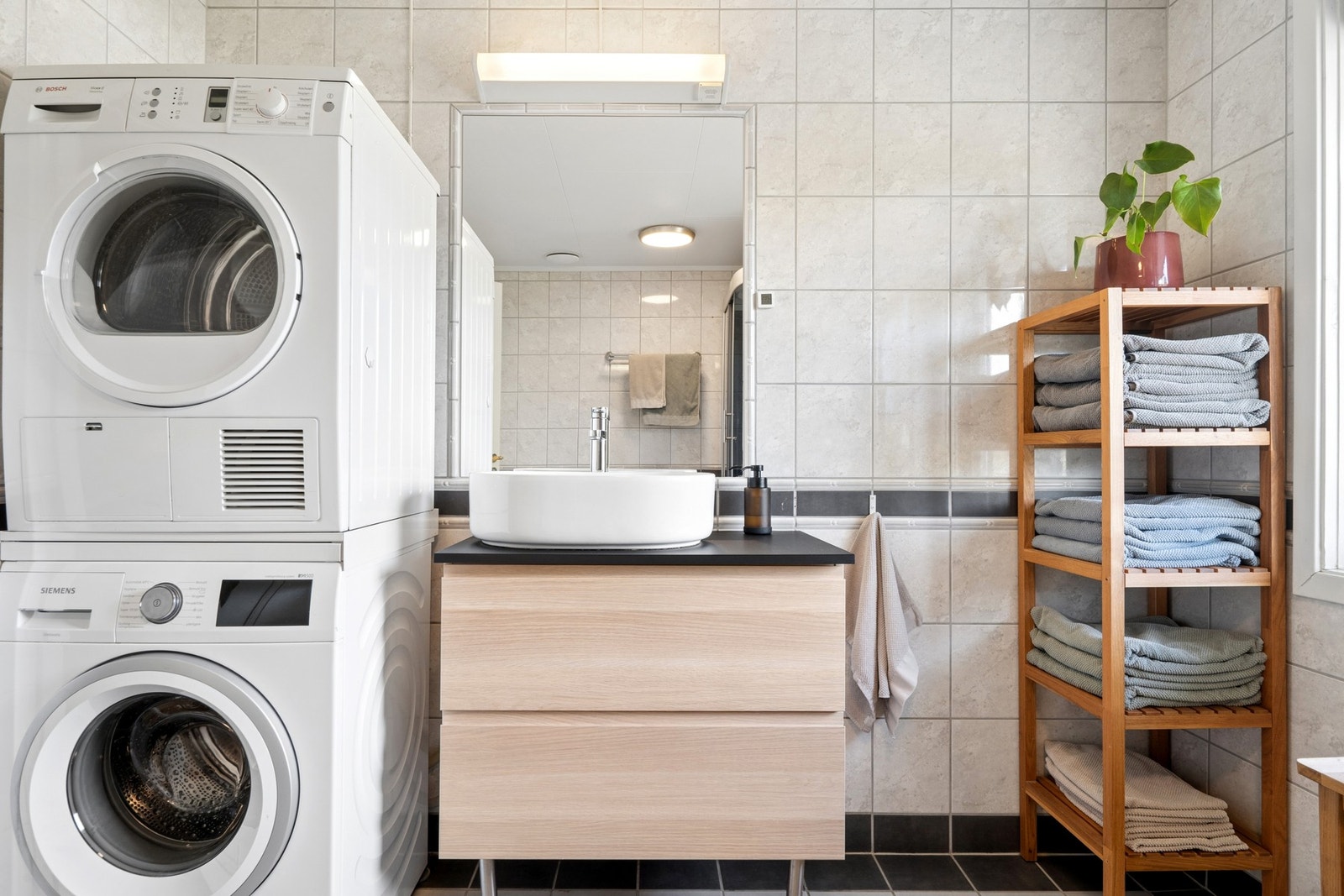 Romslig og lyst bad med moderne uttrykk og flislagte overflater. Galleribilde