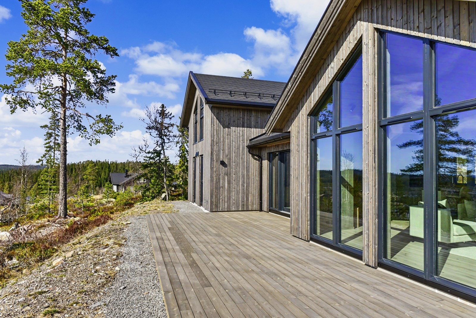 Hyttas arkitektur preges av store vindusflater som visker ut skillet mellom inne og ute, og en romslig terrasse som omkranser stuedelen. Galleribilde