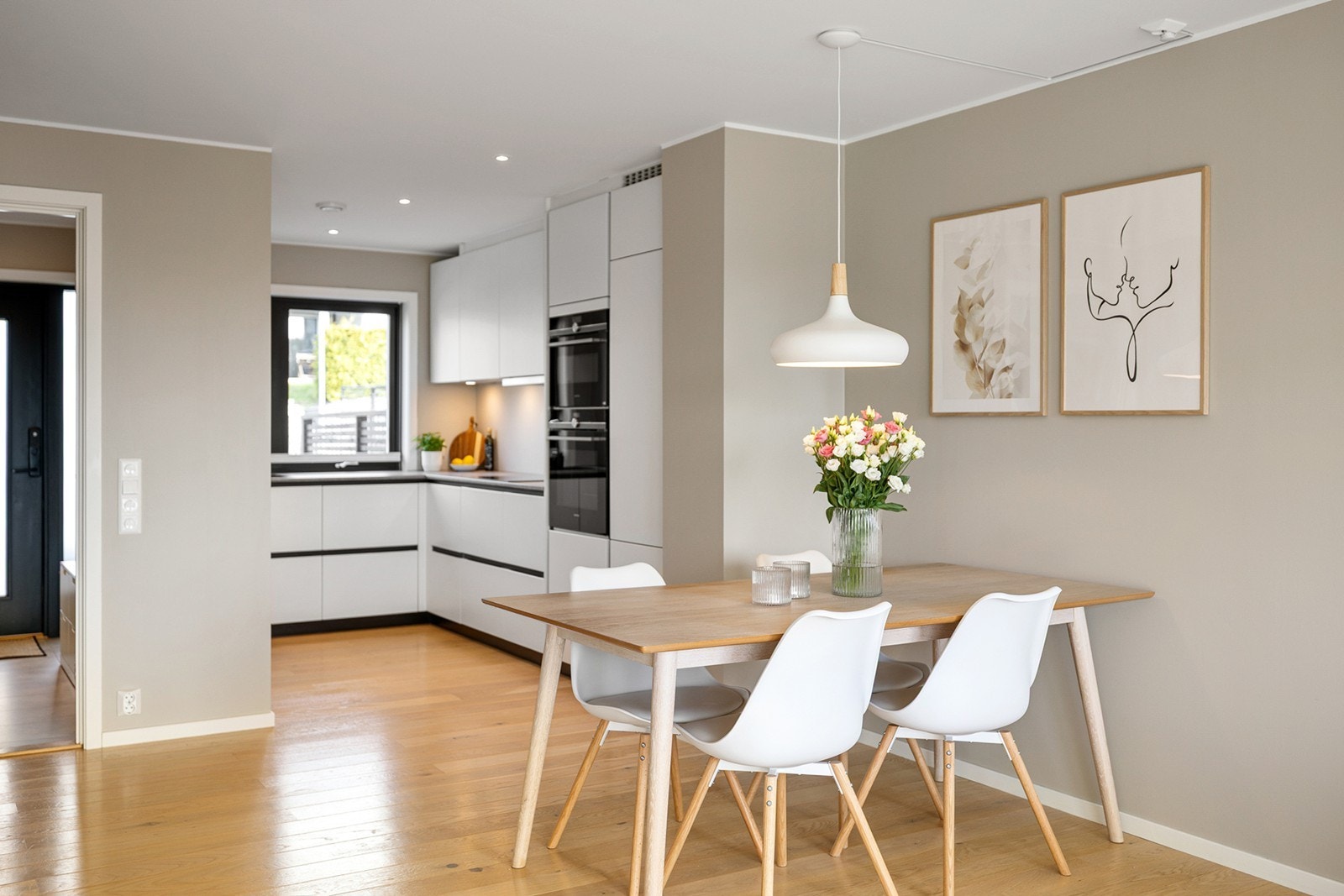 Rommet ligger i åpen løsning mot stue og spisestue, noe som gir en sosial og luftig atmosfære - perfekt for både hverdagsbruk og gjester. Galleribilde