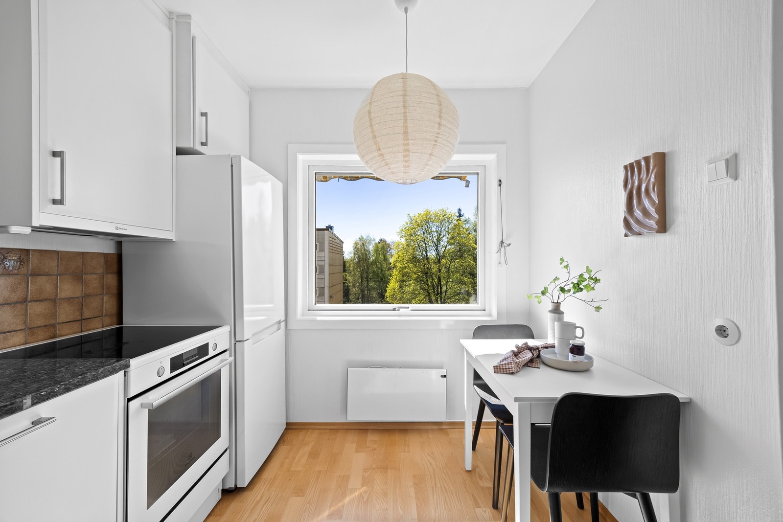 Videre er det kjøle/fryseskap, komfyr og integrert oppvaskmaskin. Her er det i tillegg god plass til et hyggelig spisebord. Galleribilde