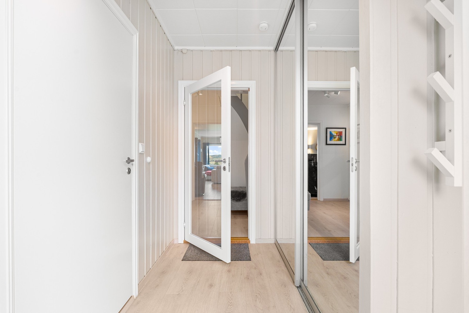 Lys og innbydende entrè med skyvedørsgarderobe. Galleribilde