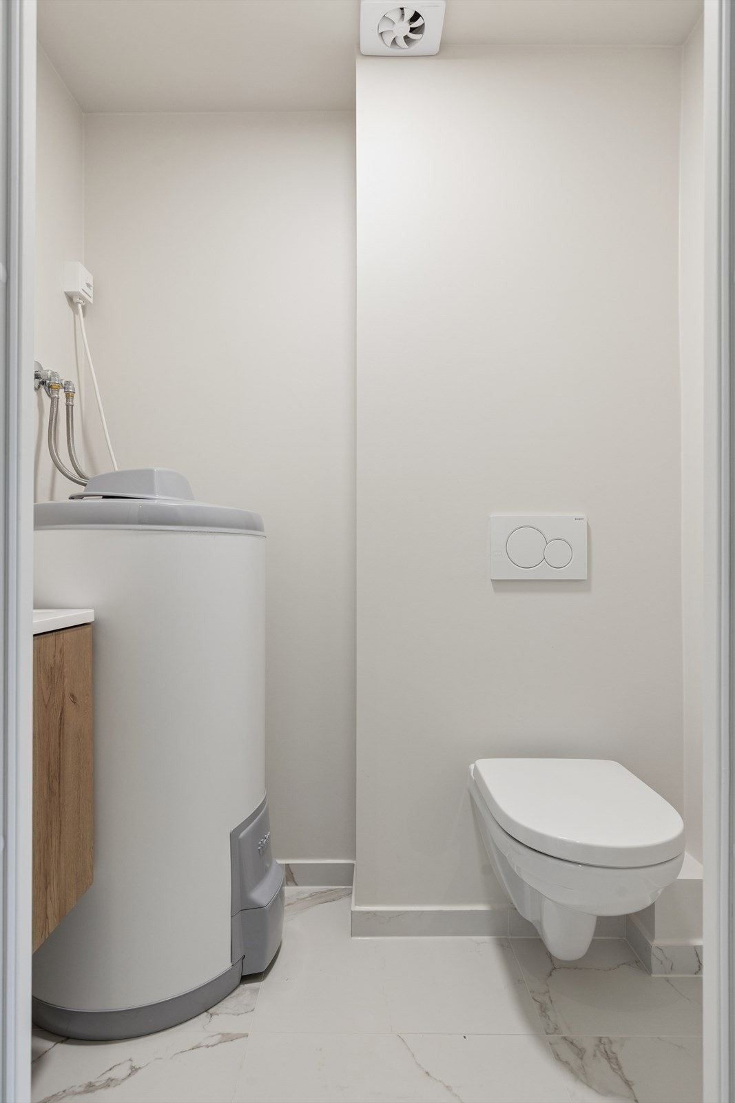 WC-rom med vask i skap og ny varmtvannsbereder. Galleribilde