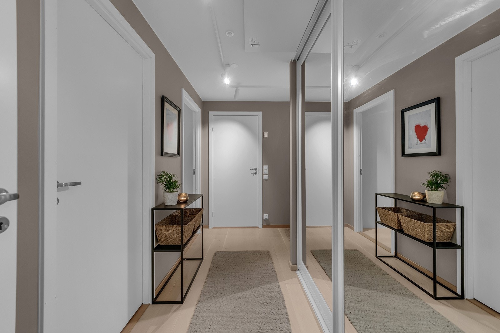Vi ønsket velkommen i en pen entré med gråbeige vegger og lys, enstavs parkett på gulvet. Yttertøyet ryddes bort i en plassbygd skyvedørsgarderobe Galleribilde