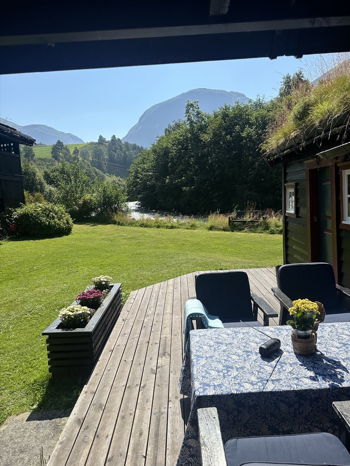 Fra en av de mange uteplassene kan du nyte utsikten mot elven og fjellene. Galleribilde