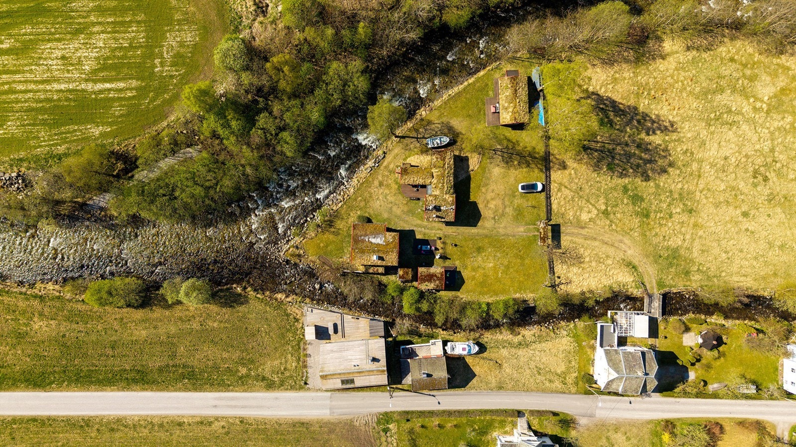 Oversiktsbilde som viser eiendommens unike plassering i landskapet, som et delta i elven. Galleribilde