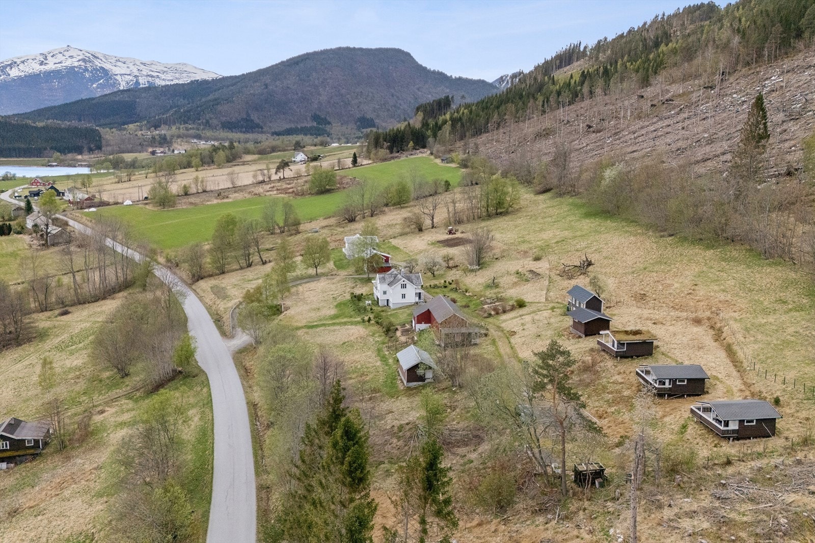 Eiendommen strekker seg over et stort område med våningshus, låve og campinghytter. Galleribilde