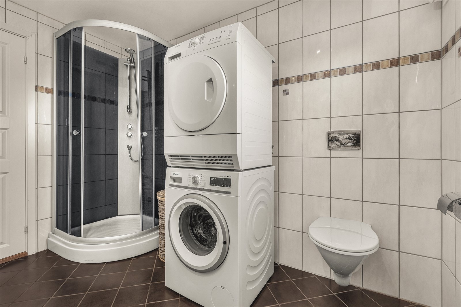 Badet har dusj, toalett og opplegg til både vaskemaskin og tørketrommel Galleribilde