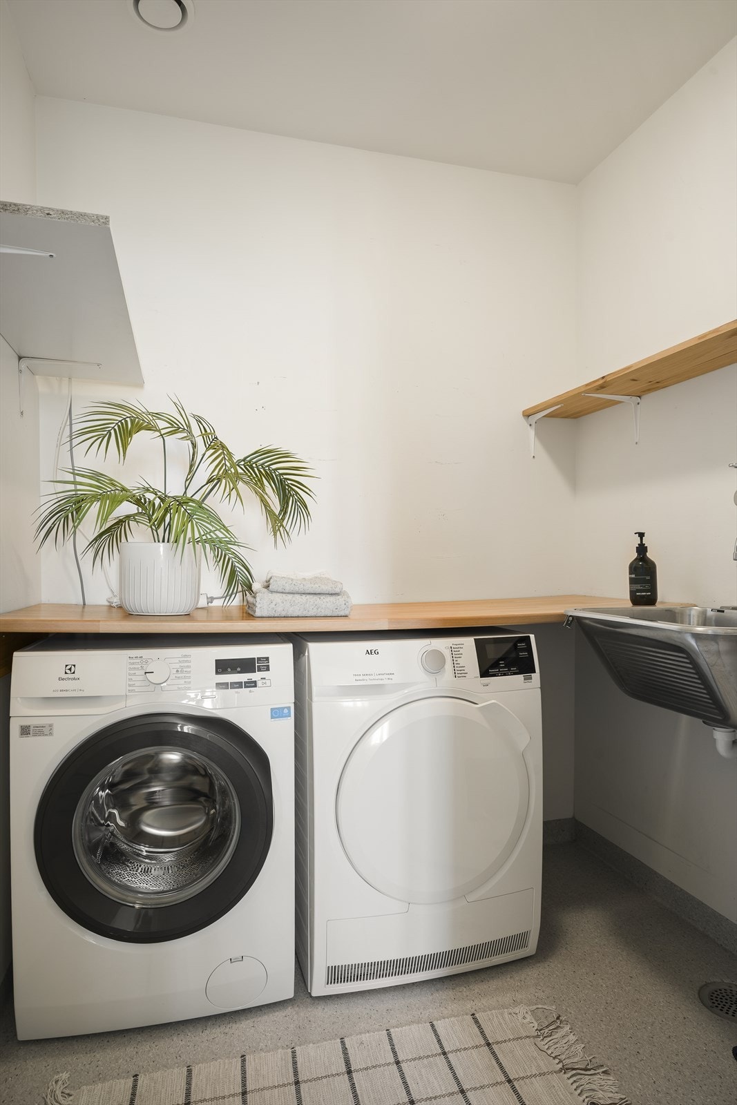 Praktisk, separat vaskerom med skyllekum, opplegg for vaskemaskin og tørketrommel, og vinylbelegg på gulvet. Galleribilde