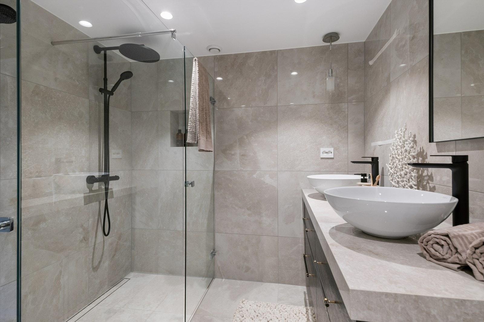 Badet har en romslig dusjnisje med glassvegger og vegghengt toalett. Galleribilde