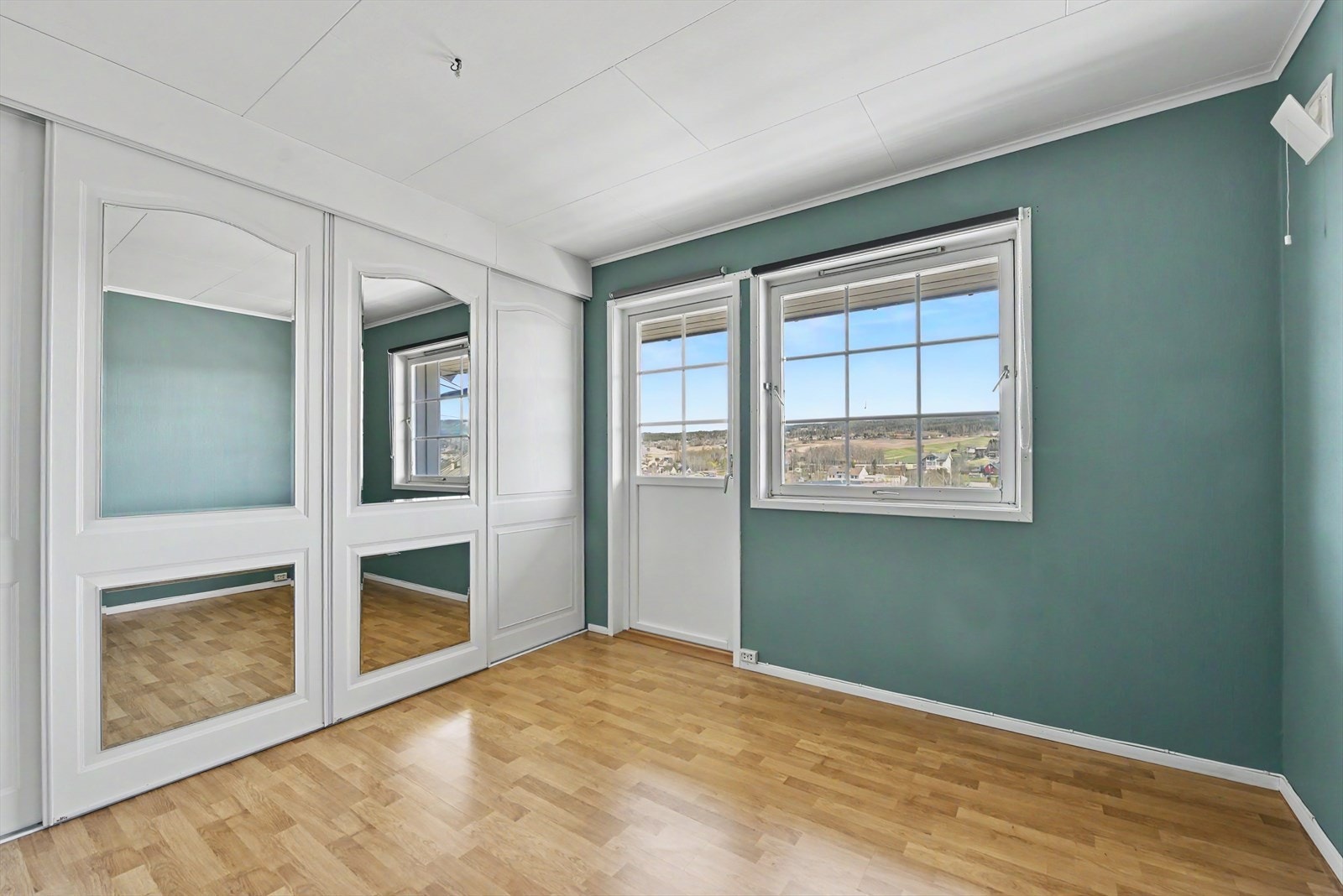 Ett av to soverom i første etasje. Rommet har god plass til dobbeltseng og en stor garderobeløsning med speilfronter. Galleribilde