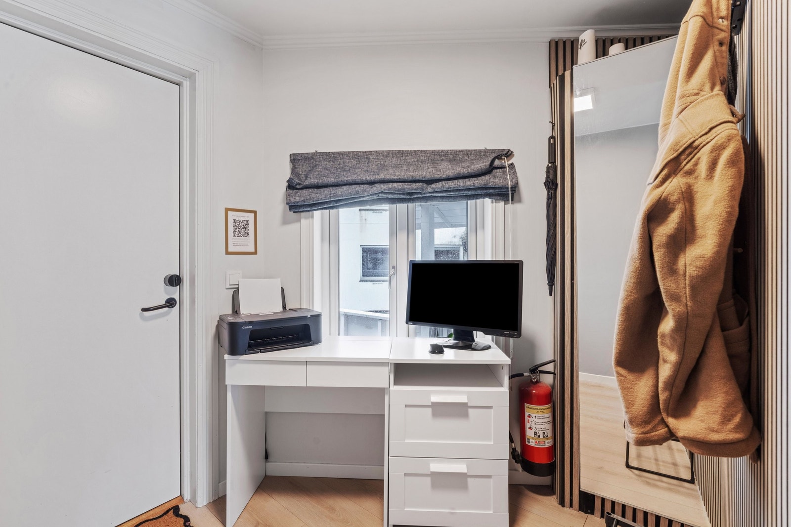 Praktisk plass med stort skap bak speil og liten kontorpult. Galleribilde