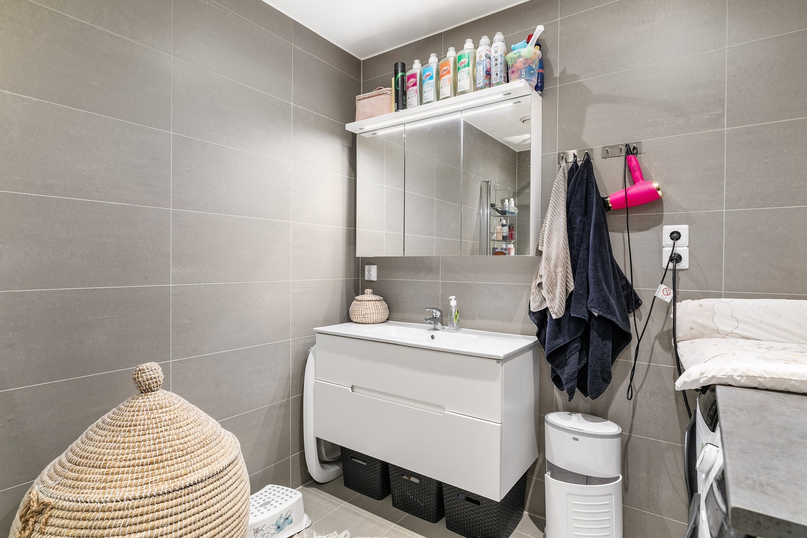 Grå fliser på både gulv og vegger gir badet helhet. I gulvet er det elektrisk varme. Galleribilde