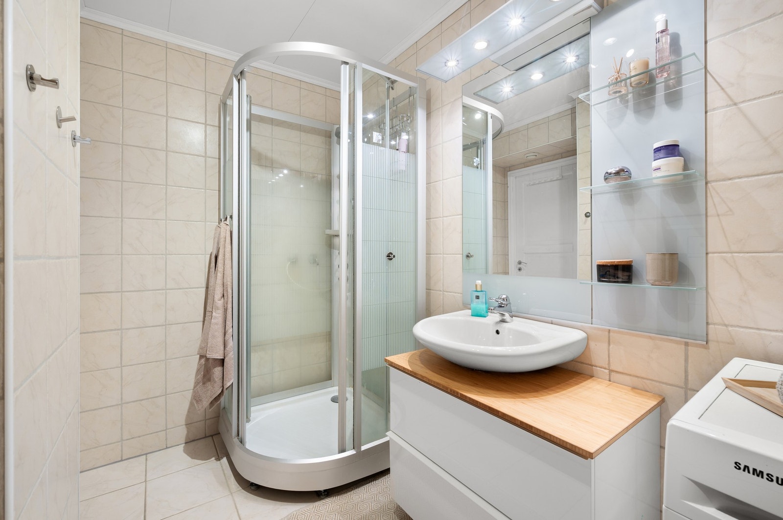 Badet er utstyrt med vegghengt servantskap og dusjkabinett. Galleribilde
