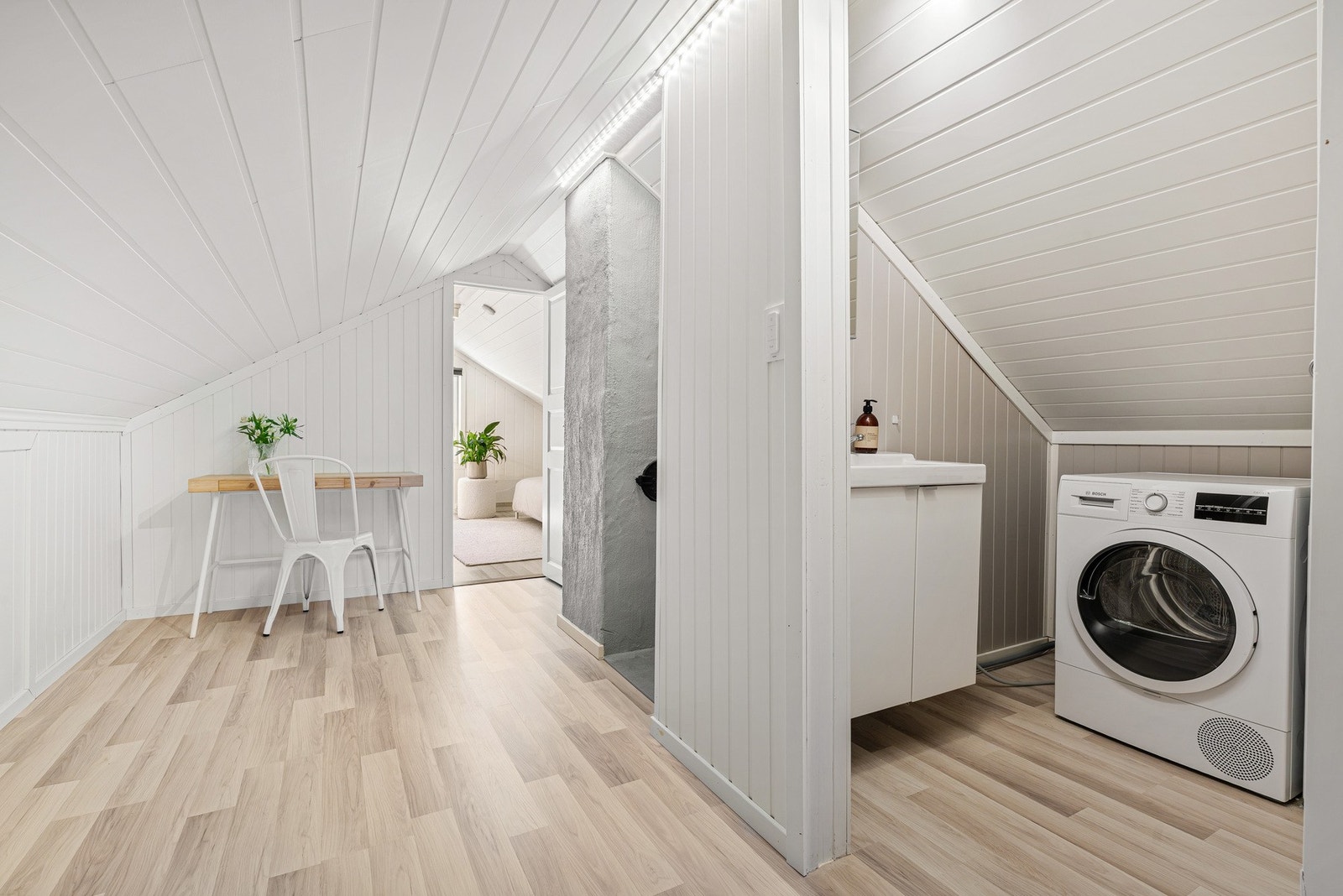 Det er laget til et praktisk wc-rom med opplegg for vaskemaskin (ikke godkjent) Galleribilde