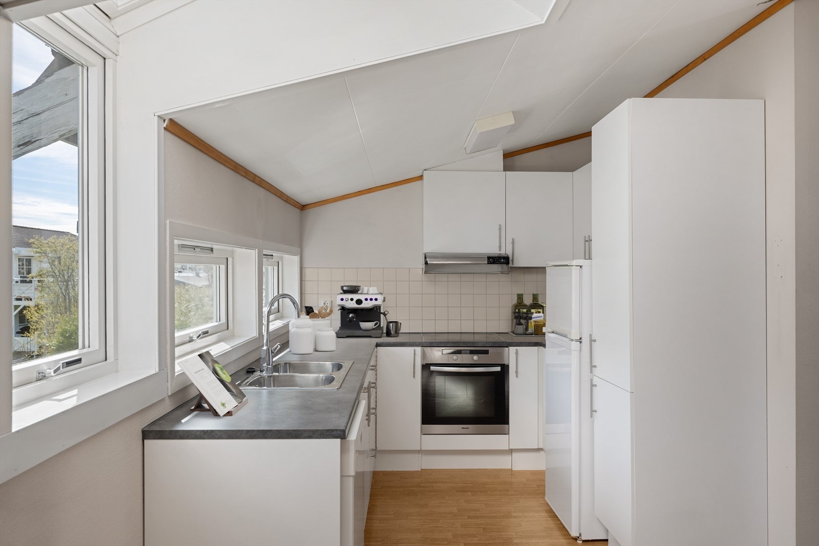Kjøkkenet er utstyrt med innredning med over-og benkeskap, laminert benkeplate og integrerte hvitevarer med komfyr, platetopp og ventilator Galleribilde